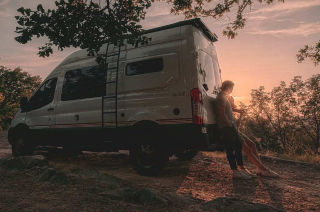 The Alabama made Storytellers 4x4 Camper with a couple leaning against it at sunset