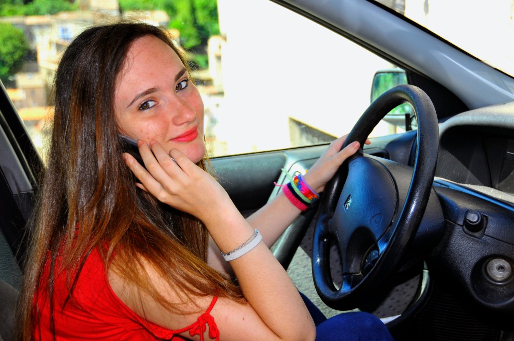 Teenager using a phone at the wheel. 