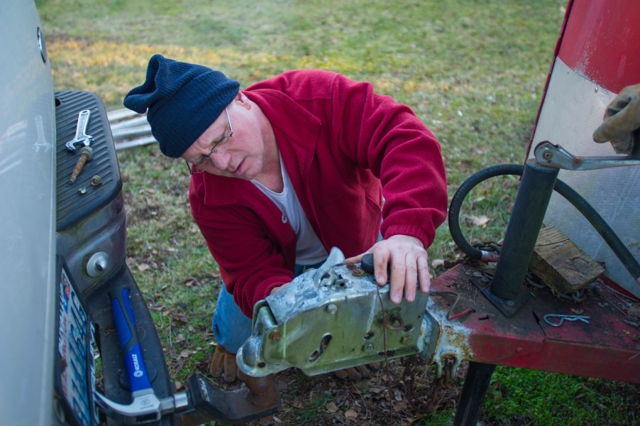 A man hitches a horse trailer to a trailer hitch