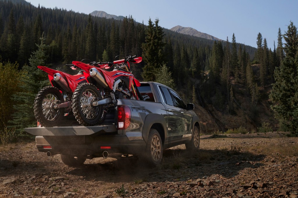This is a publicity photo of a gray Honda Ridgeline carrying a pair of dirt bikes. The Ridgeline has the third smallest truck bed.