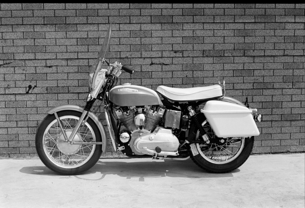 The side view of a 1967 Harley-Davidson XLH Sportster parked against a building