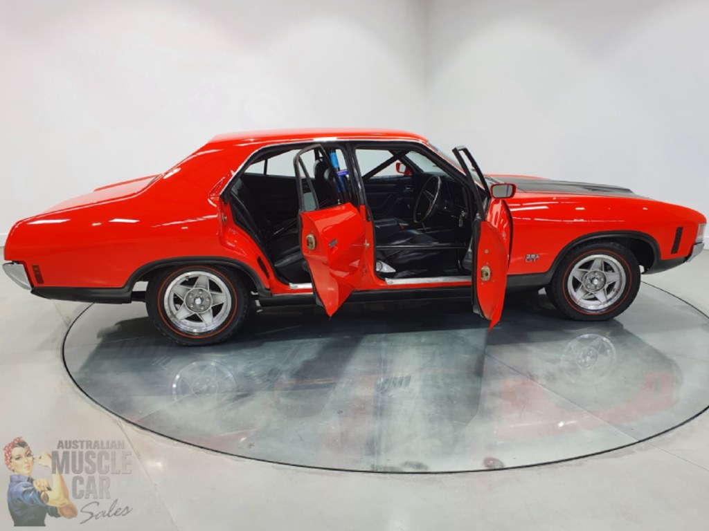 The side view of the liveried red-and-black 1972 Ford Falcon XA GTHO Phase IV prototype showing the full interior roll cage
