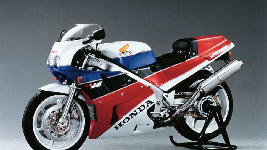 A white-red-blue-and-black 1988 Honda VFR750R RC30 on a rear-wheel stand