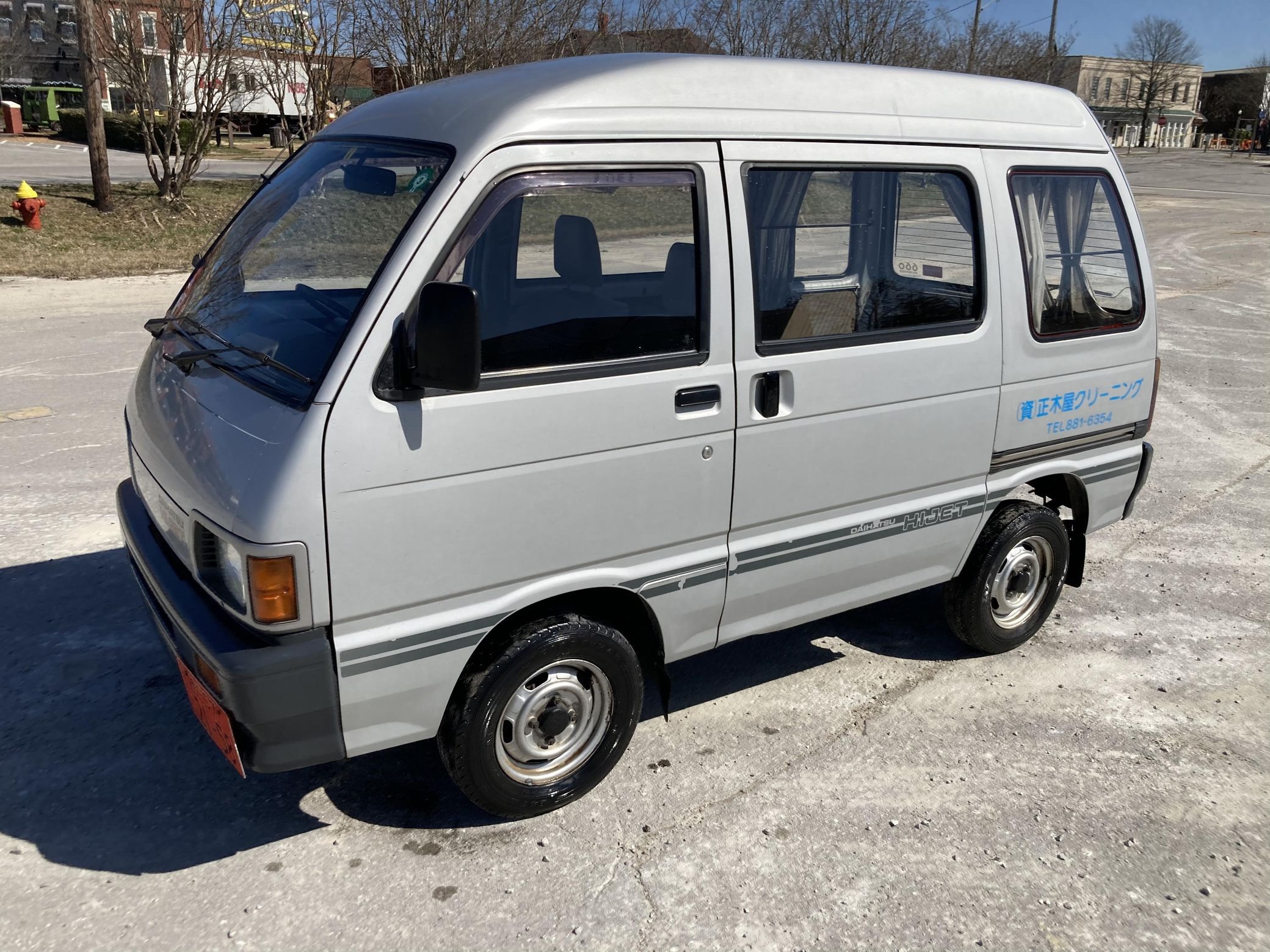 A silver 1992 Daihatsu Hijet kei car van in a parking lot