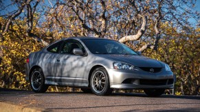 A gray 2006 Acura RSX Type S on a tree-lined road