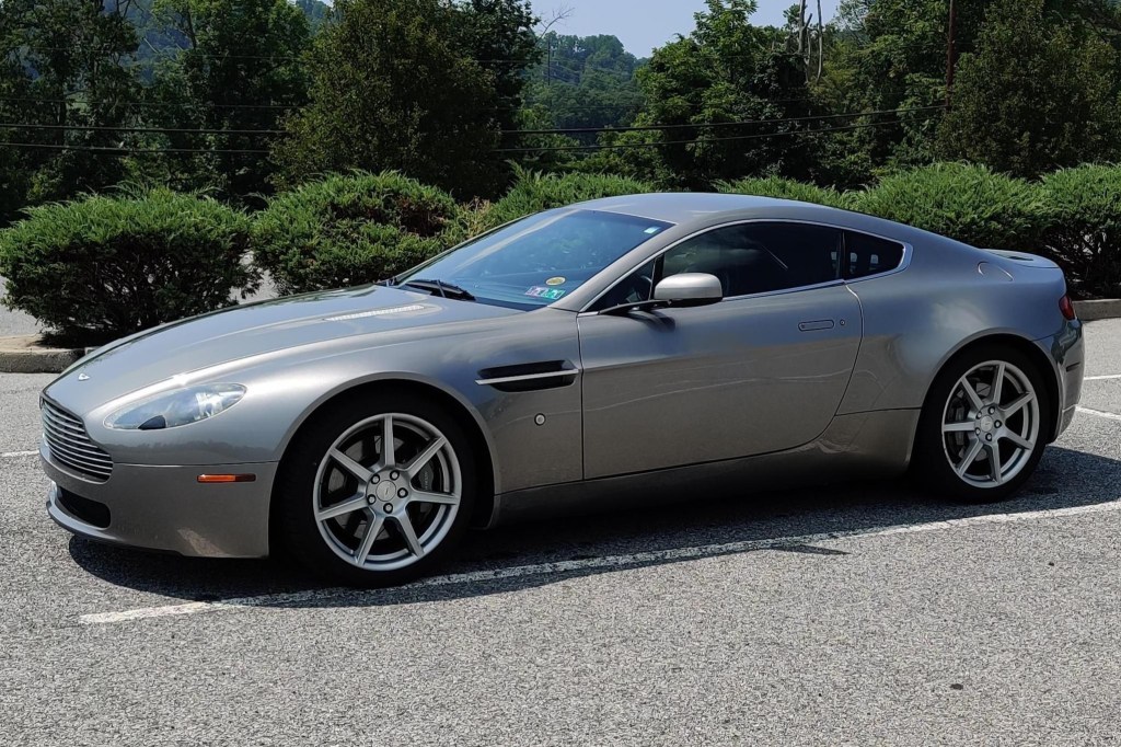 The side 3/4 view of a gray 2008 Aston Martin V8 Vantage in a parking lot
