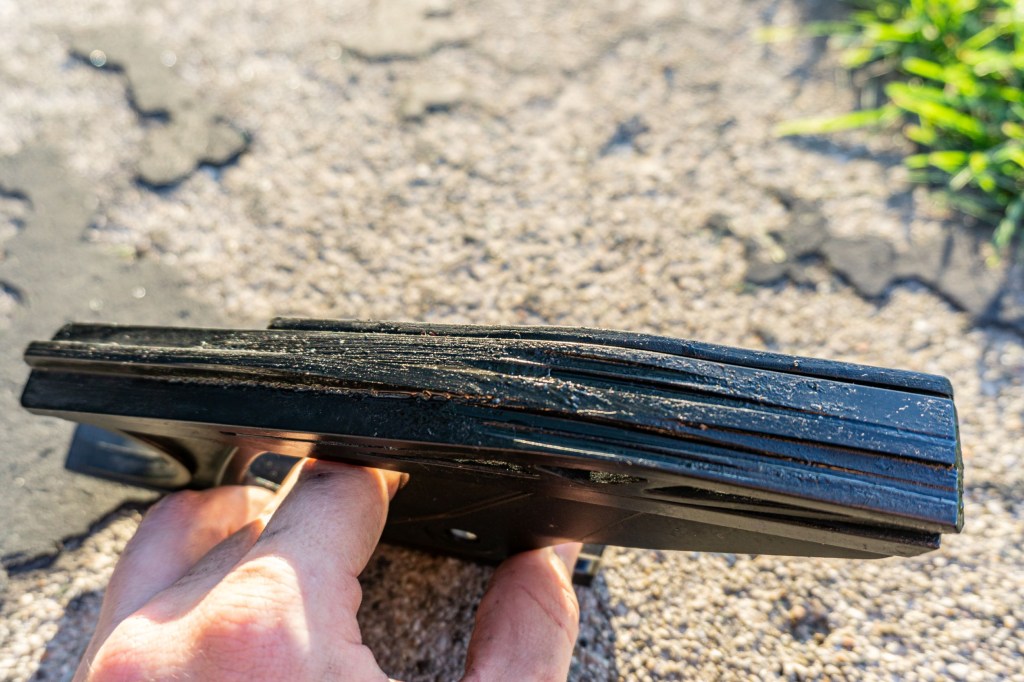 The top of a damaged black 2012 Triumph Street Triple R's motorcycle chain slider