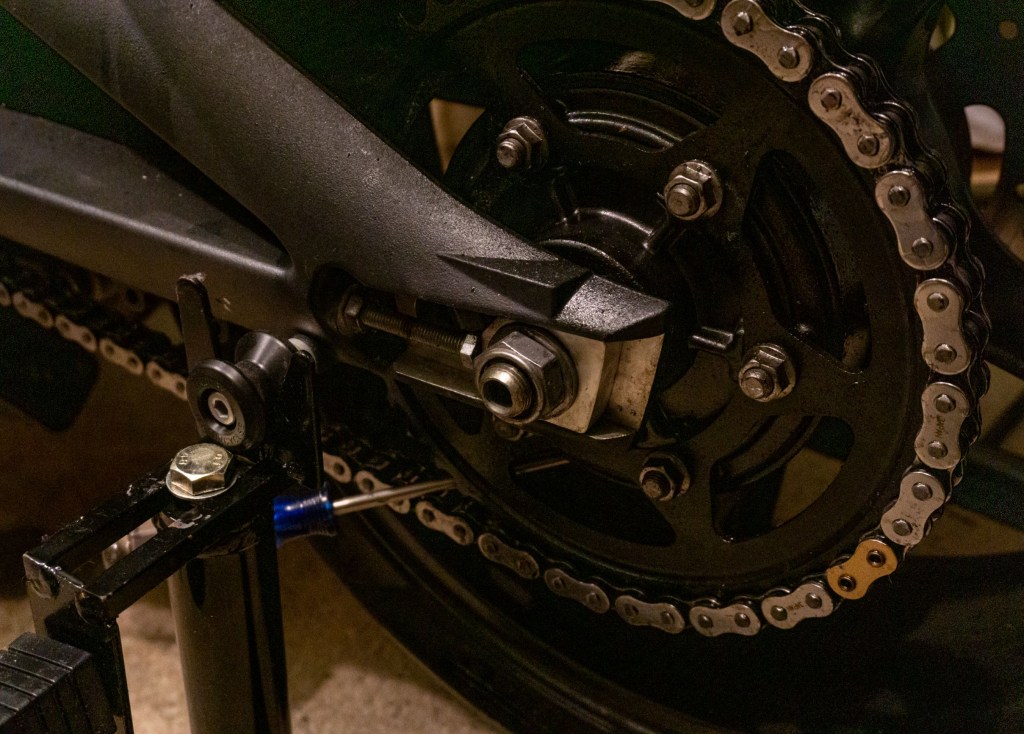 A 2012 Triumph Street Triple R with a screwdriver in its rear sprocket