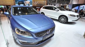 A white 2013 Volvo XC60 on display next to a blue V60 at the 38th Geneva Motor Show in March 2013