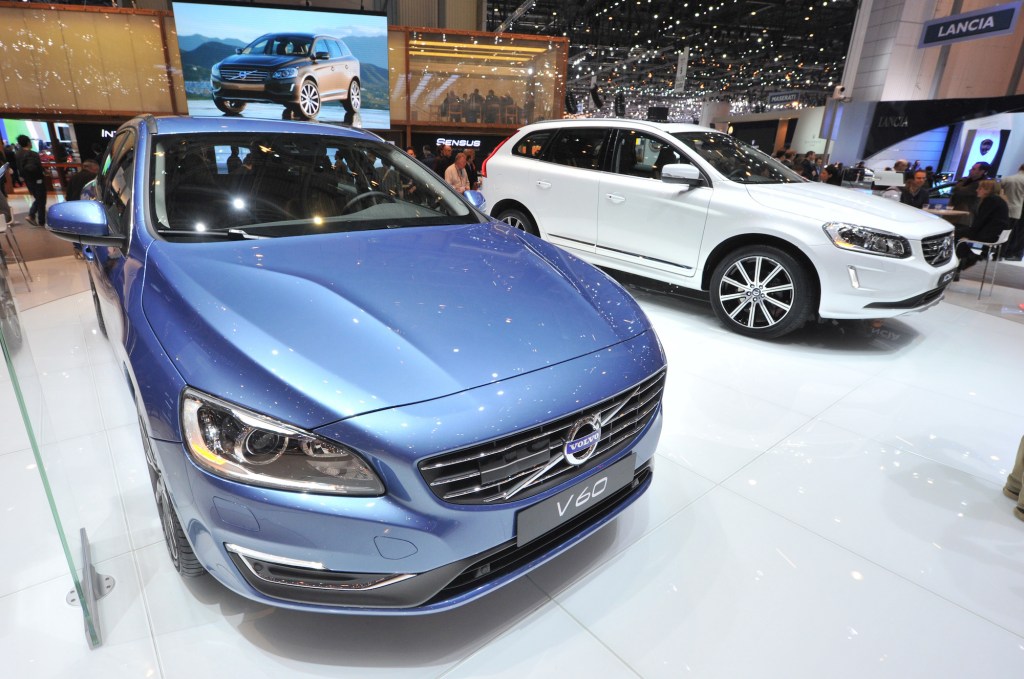 A white 2013 Volvo XC60 on display next to a blue V60 at the 38th Geneva Motor Show in March 2013