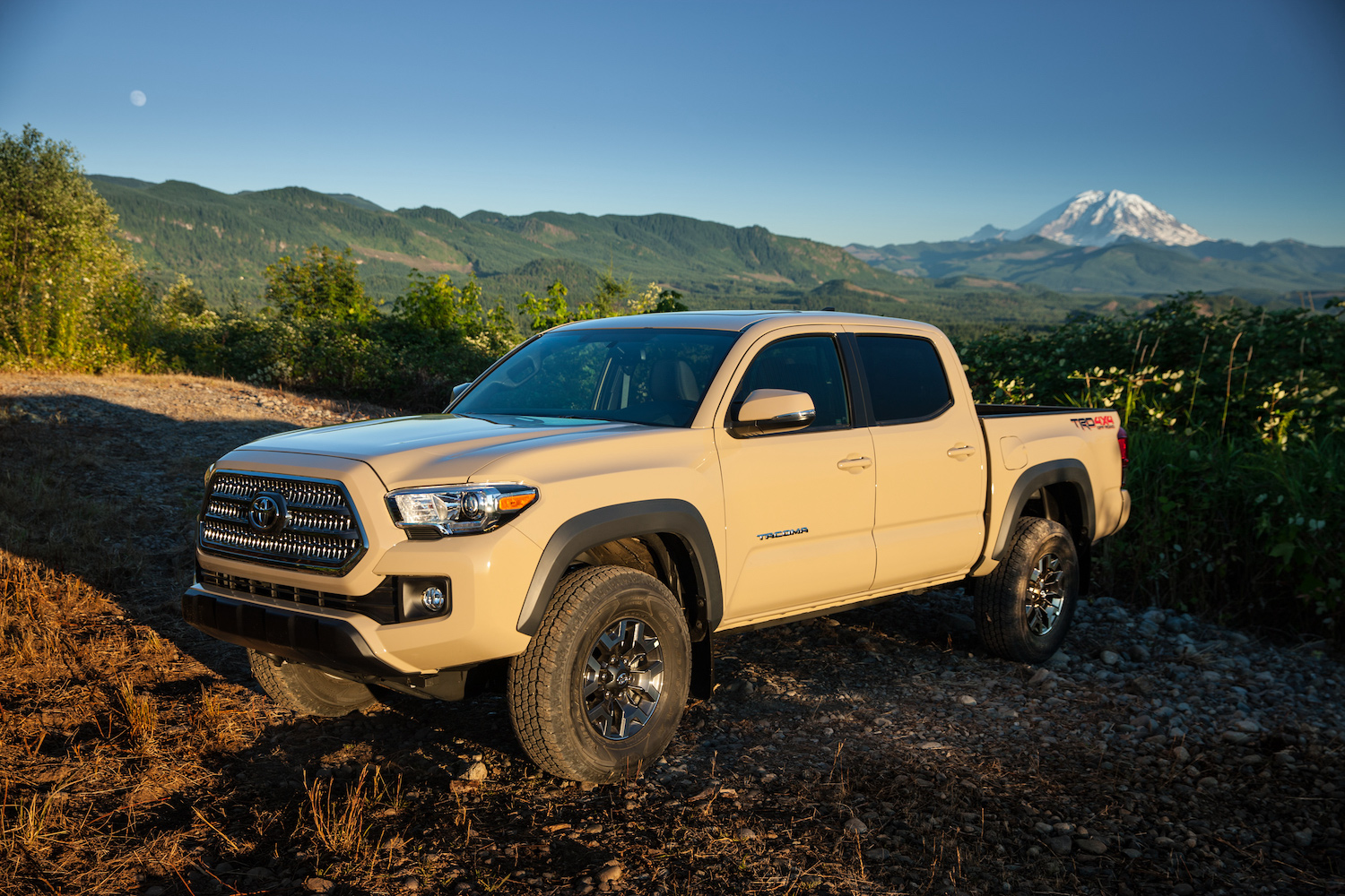 A tan 2017 Toyota Tacoma parked in front of mountains, the 2017 Toyota Tacoma is one of the best used trucks under $30K