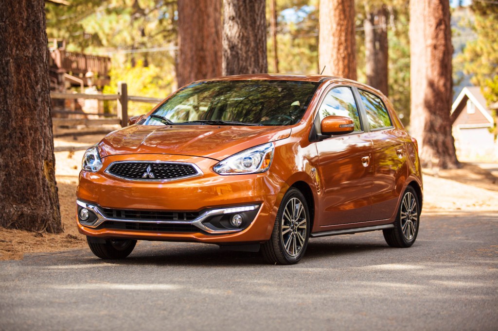 An orange 2019 Mitsubishi Mirage parked in fall, the Mirage is one of the worst used cars and should be skipped for one of the best used cars instead