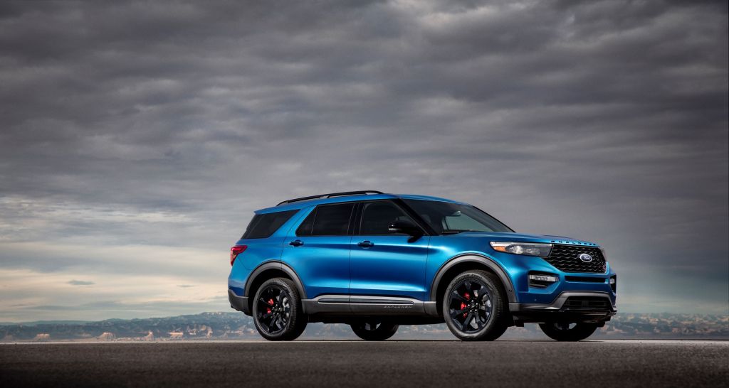 The side 3/4 view of a blue 2020 Ford Explorer ST in the desert