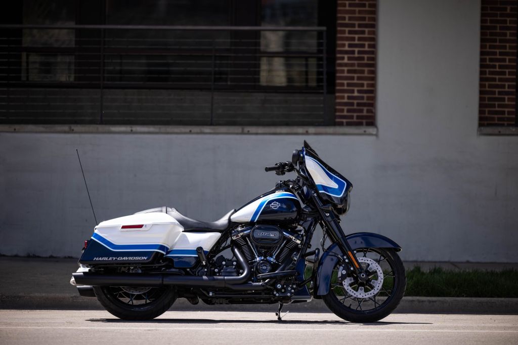 The side view of a white-blue-and-black 2021 Harley-Davidson Arctic Blast Street Glide Special in front of an old building