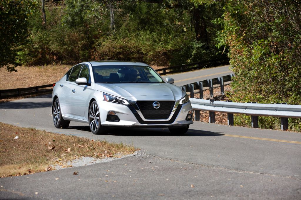 The 2021 Nissan Altima sedan in silver gray driving on a country highway