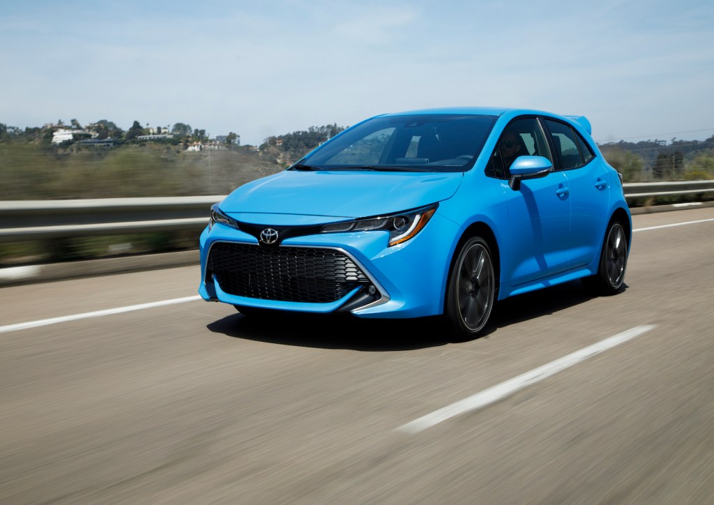 A blue 2021 Toyota Corolla Hatchback driving down an empty road, the 2021 Toyota Corolla Hatchback is one of the least reliable Toyota models