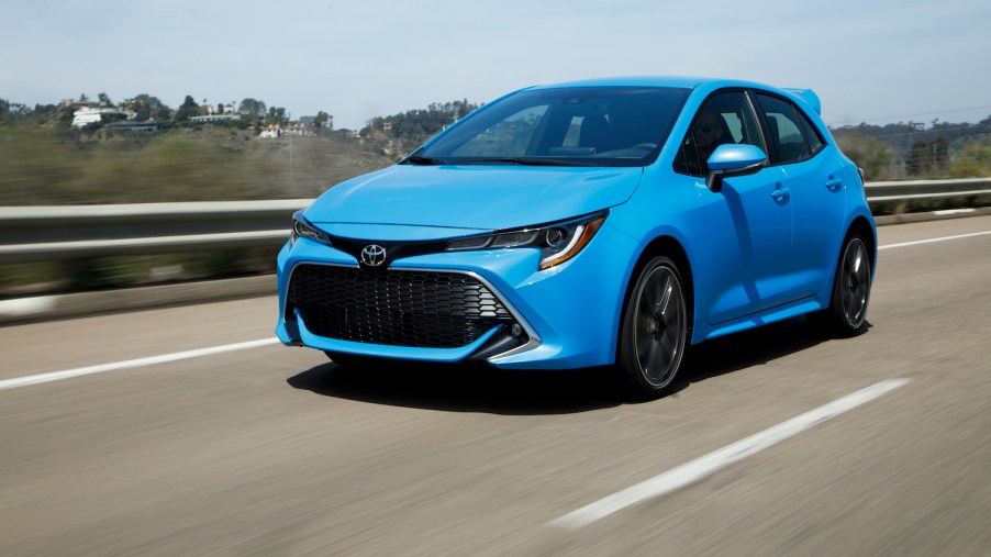 A blue 2021 Toyota Corolla Hatchback driving down an empty road, the 2021 Toyota Corolla Hatchback is one of the least reliable Toyota models