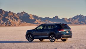 A dark blue 2021 Volkswagen Atlas SUV model parked in the middle of a desert plain
