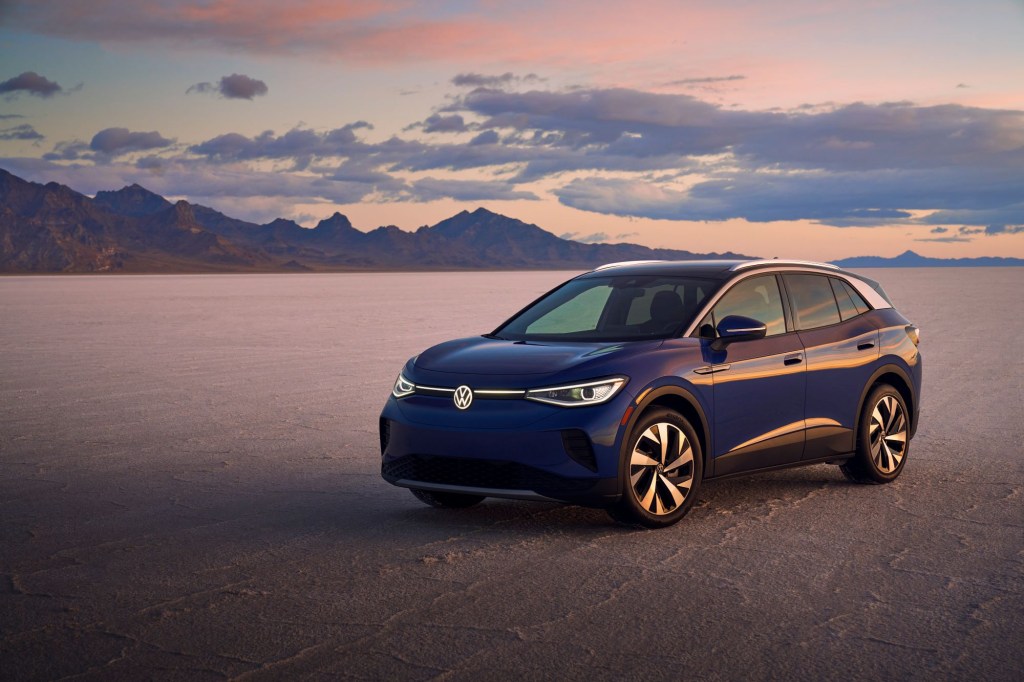 The 2021 Volkswagen ID.4 Pro S EV SUV model parked on a barren plain near mountains and a setting sun