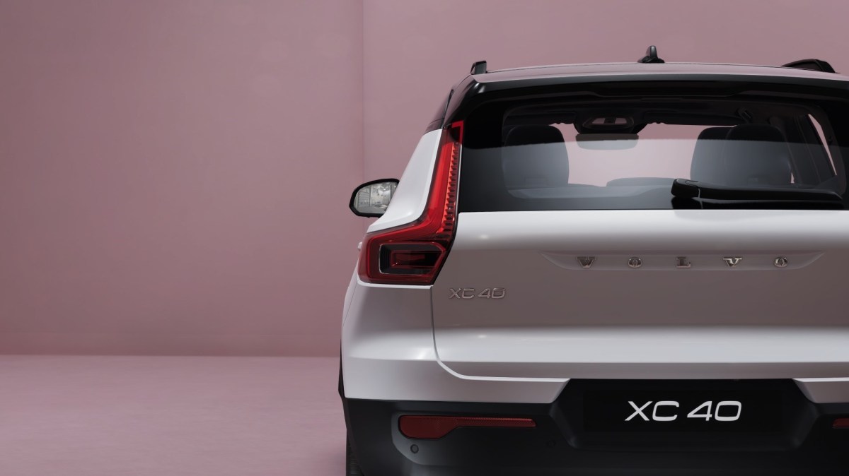 A rear view of a 2021 Volvo XC40 Recharge electric compact crossover SUV parked in a pink room