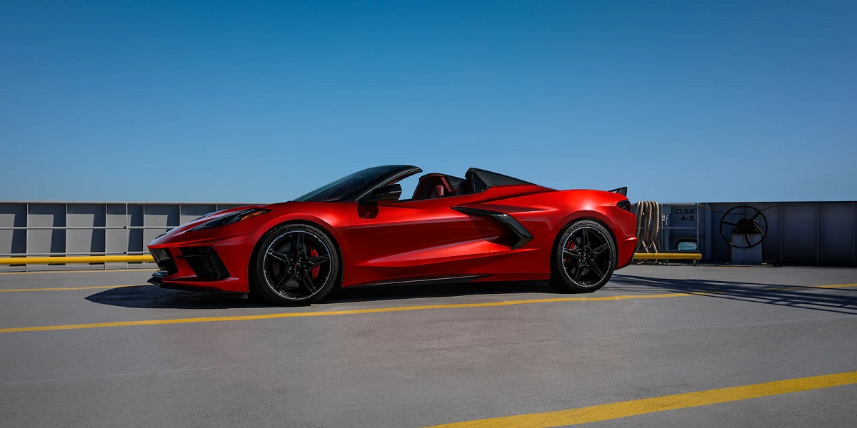 A red 2021 Chevy Corvette parked with a blue sky behind it.