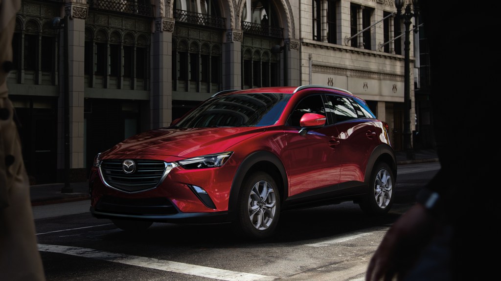 A red 2021 Mazda CX-3 at a stop line. The Mazda CX-3 is one of the cheapest SUVs you can buy.
