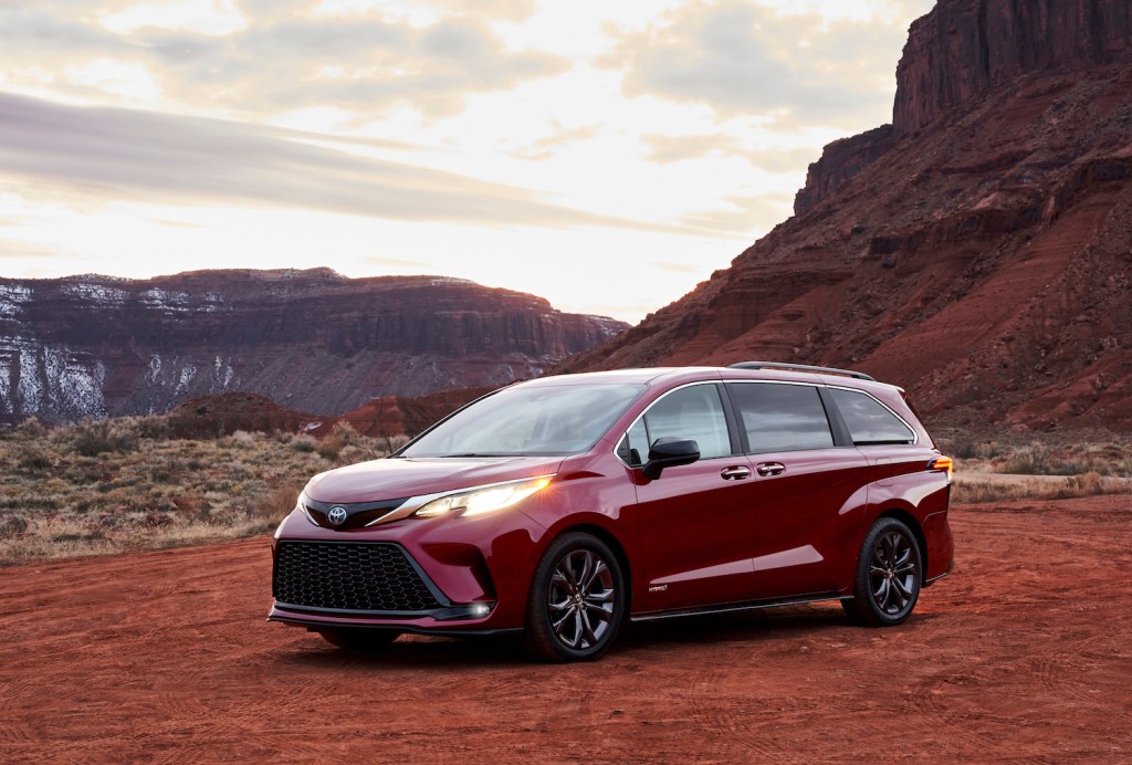 A red 2021 Toyota Sienna parked in the wilderness on a cloudy day