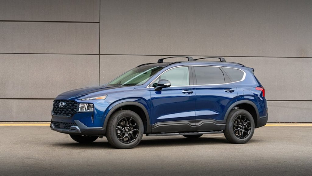 A blue 2022 Hyundai Santa Fe XRT parked near a building