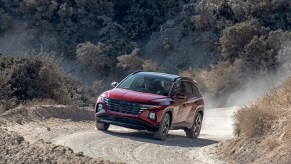 A red 2022 Hyundai Tucson driving up a dirt hill, the 2022 Hyundai Tucson is the best AWD SUV of 2021