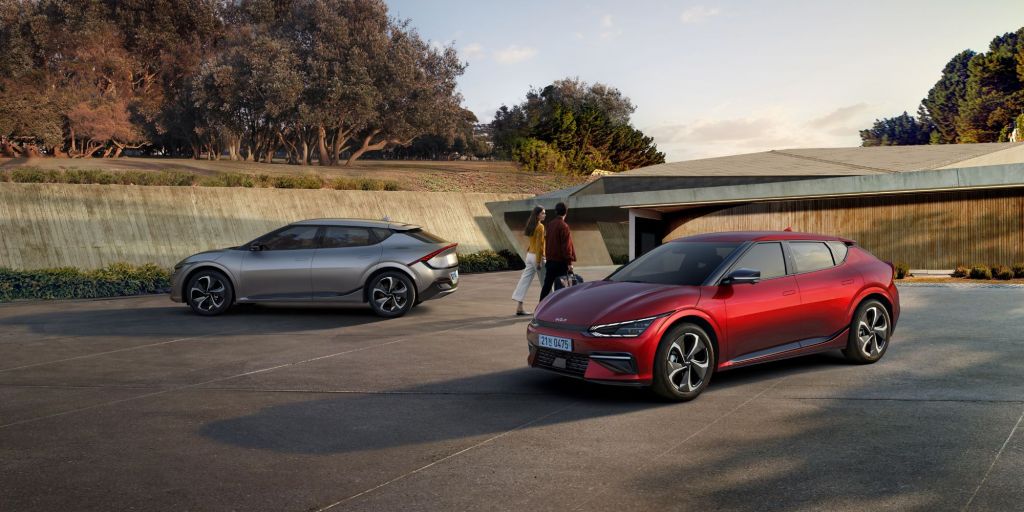 2022 Kia EV6 models in silver and red parked as a couple walks past