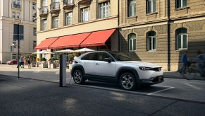 The 2022 Mazda MX-30 EV parked and charging at a charging station