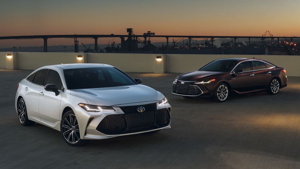 two 2022 Toyota Avalon models parked on a road near the shore