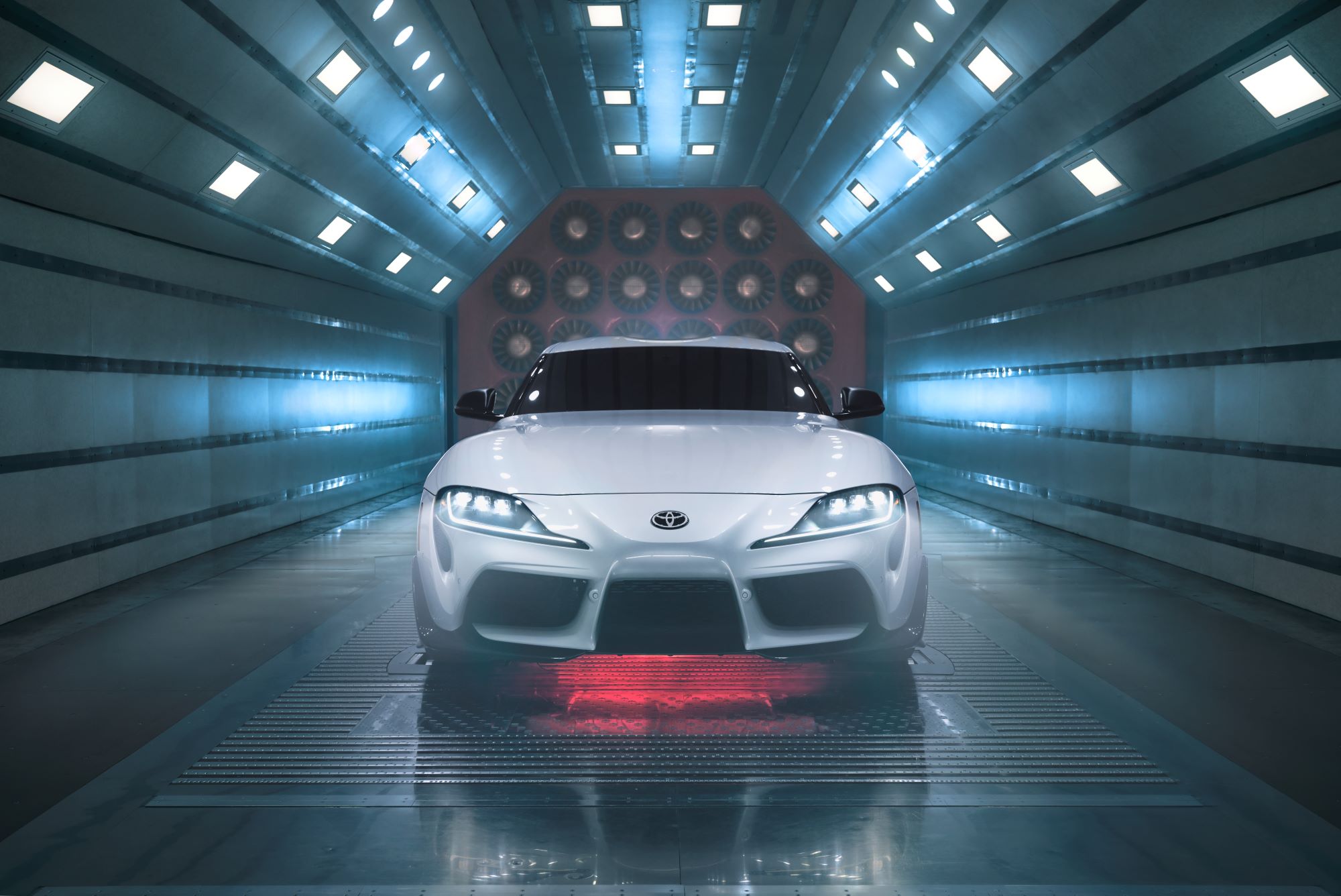 A silver 2022 Toyota Supra in a wind tunnel with lights.