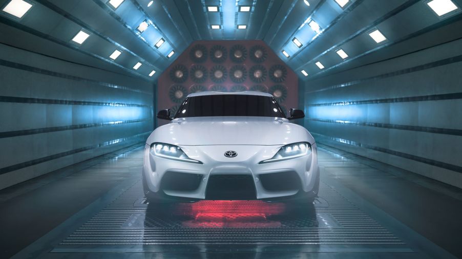 A silver 2022 Toyota Supra in a wind tunnel with lights.
