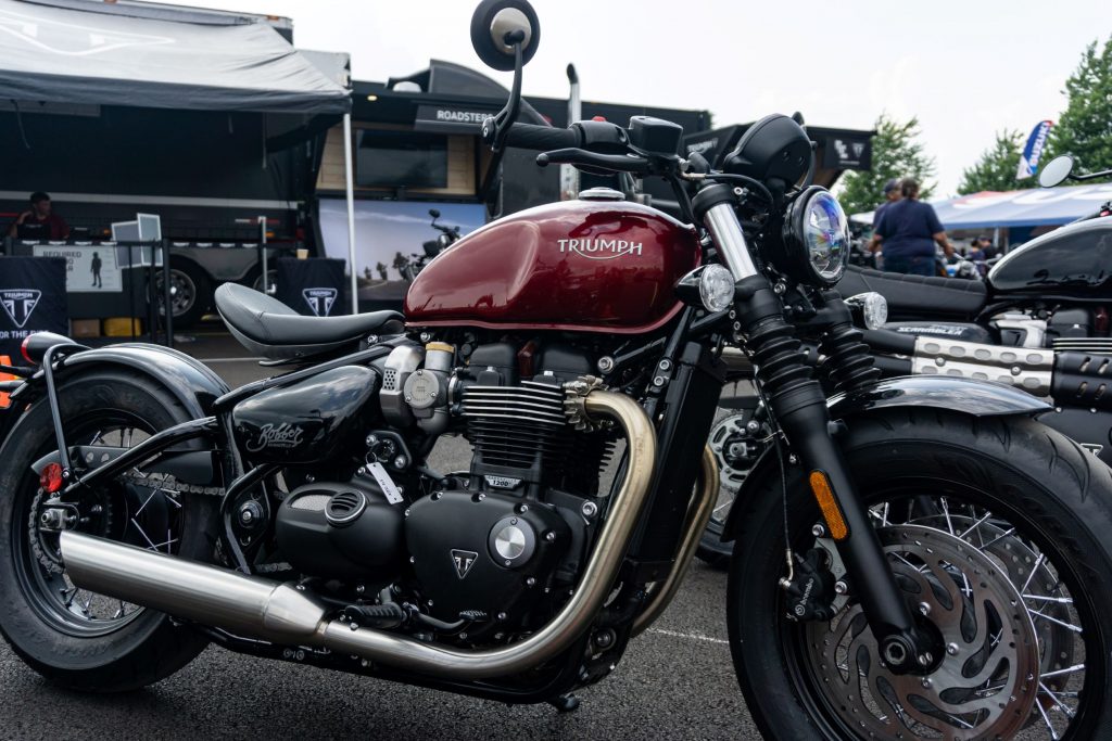 The side 3/4 view of a red 2022 Triumph Bonneville Bobber in a parking lot