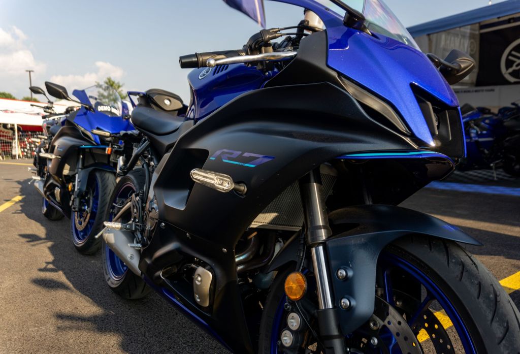 The front 3/4 view of a blue-and-black 2022 Yamaha YZF-R7 in front of another R7