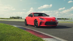 A red Toyota GR 86 on track at a launch event
