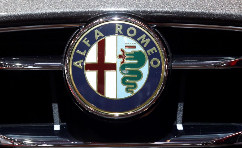 The Alfa Romeo logo on the grill of a silver car. 