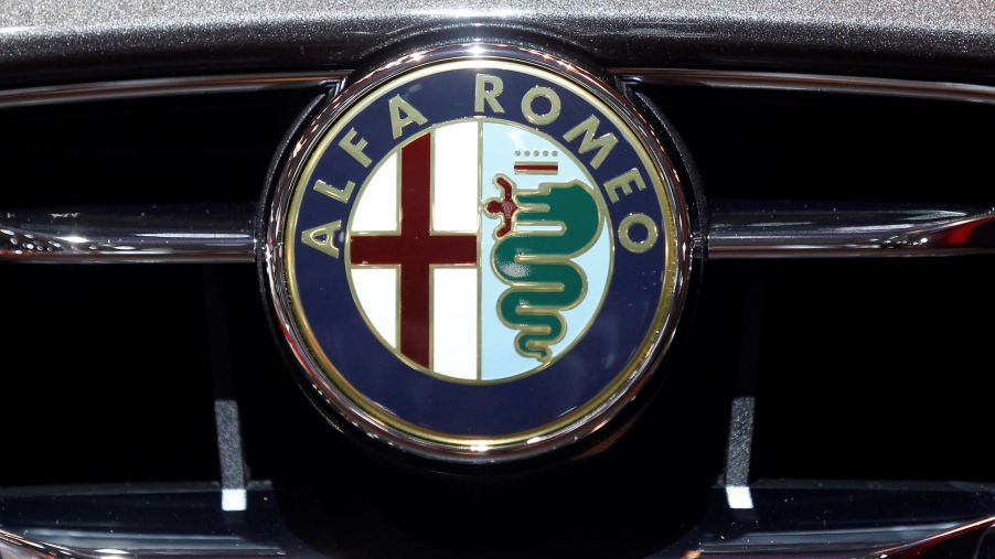 The Alfa Romeo logo on the grill of a silver car.
