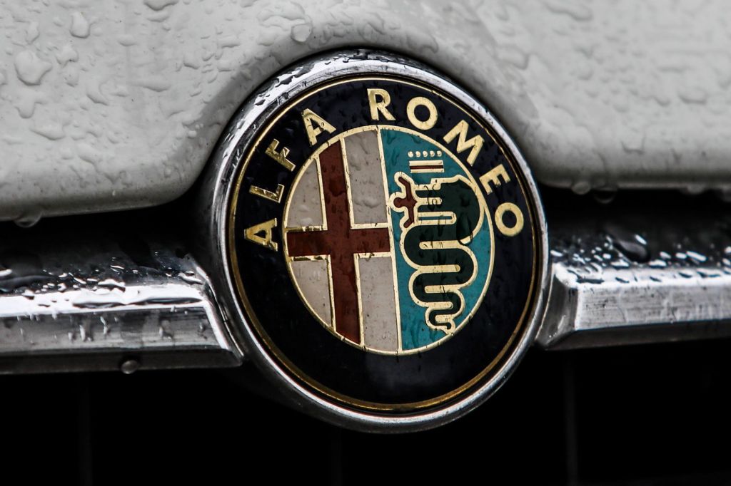 Alfa Romeo logo on a grey car with rain drops.