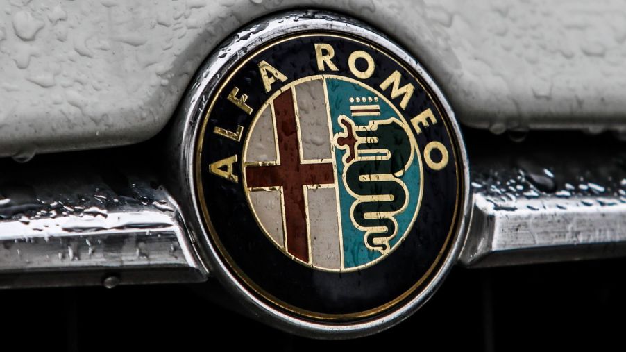 Alfa Romeo logo on a grey car with rain drops.