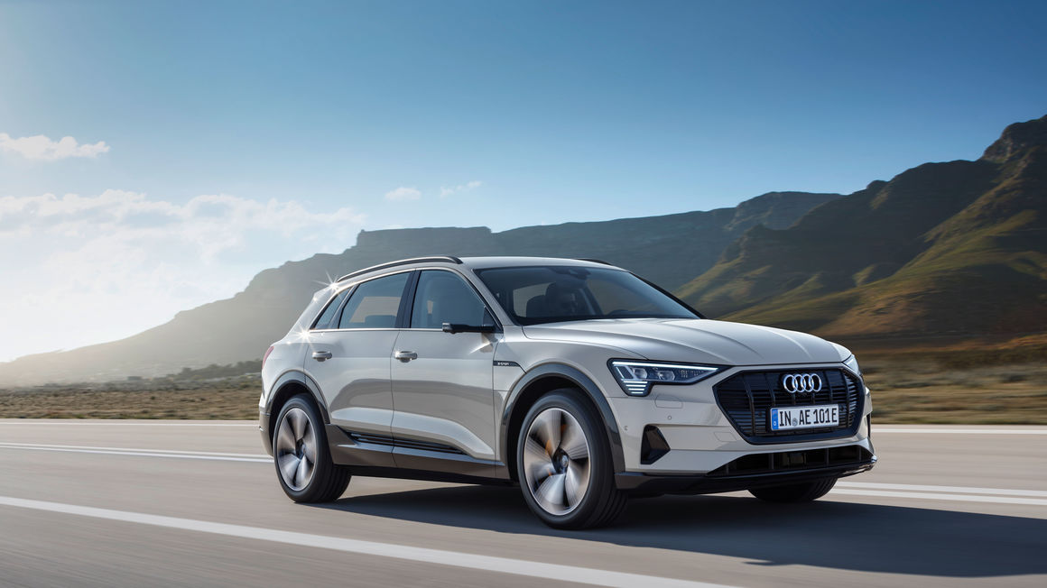 The Audi e-tron EV SUV model driving on a country highway