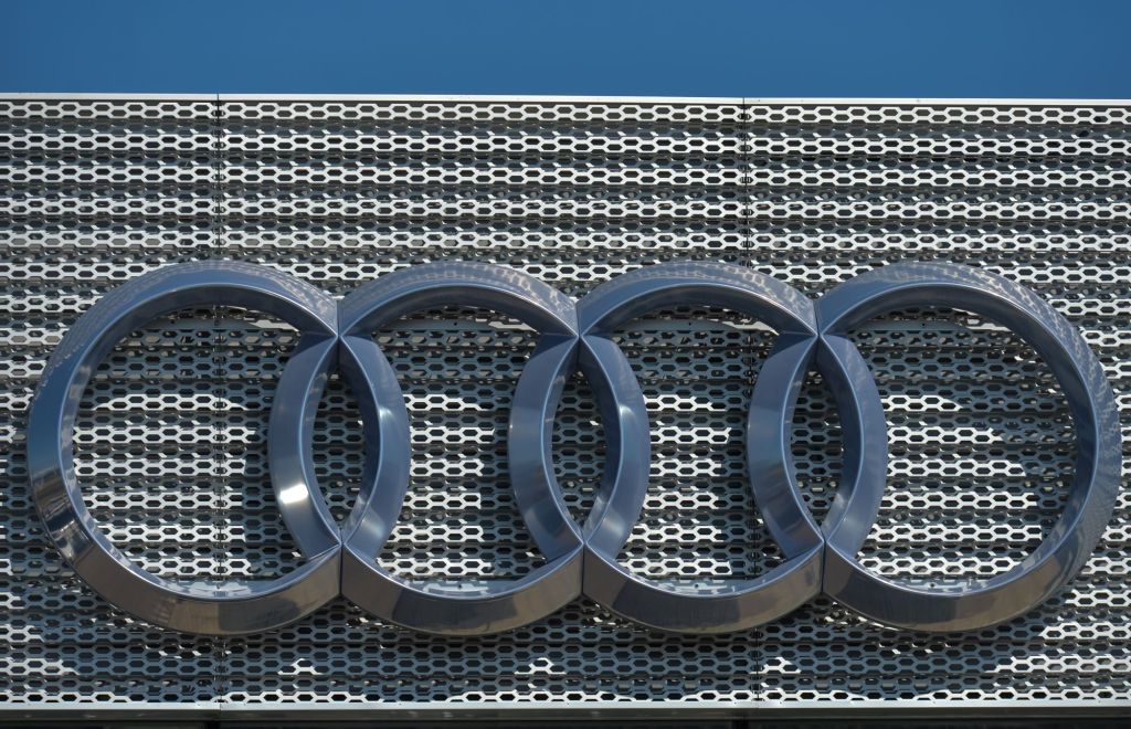Chrome Audi logo on a mesh grille looking background.