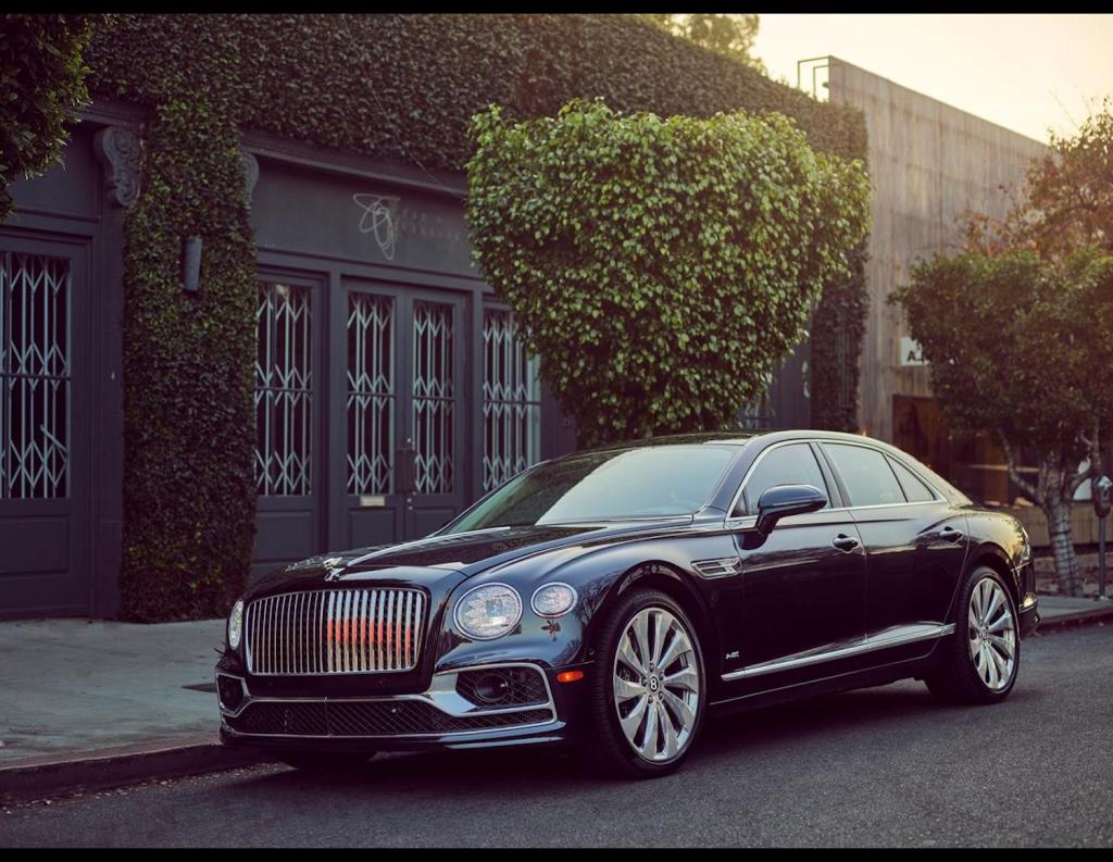 Press photo of a black 2021 Bentley Flying Spur parked on the street, one of Car and Driver's most beautiful sedans of 2021