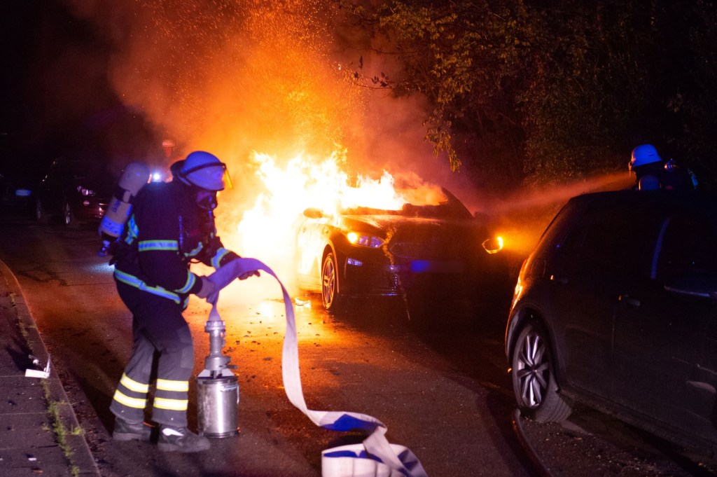 Firefighters extinguishing a car fire in Bahrenfeld.