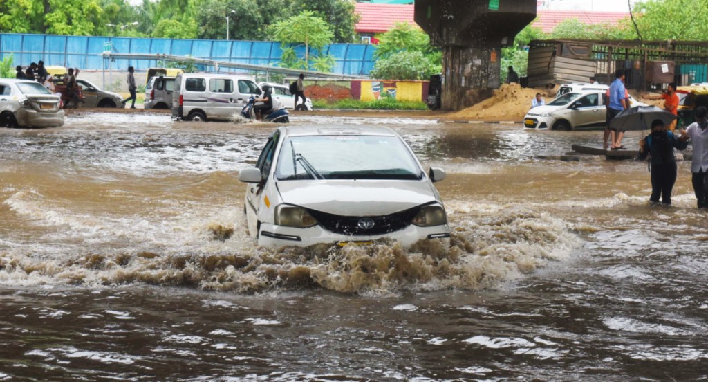 Cars cross a waterlogged area. 