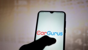 In this photo illustration, the CarGurus logo is displayed on a smartphone app