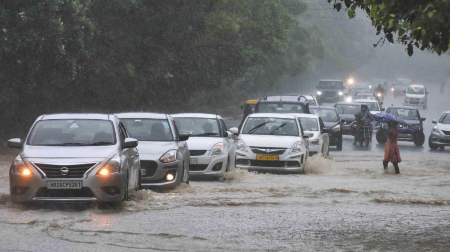 Cars cross a waterlogged area.