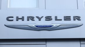 Chrysler logo on a building with the brand name written in front of it.