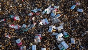 Cigarette packets and other trash washed up on Chesil Beach after a cargo ship accident
